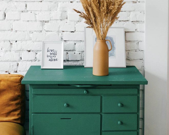 forest green drawer decorated with a portrait and a vase